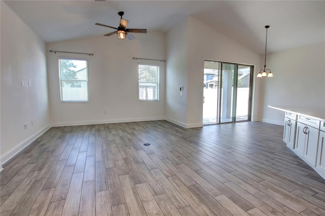 1727 Butterfly Way, Longwood, FL 32750 - unfurnished living room featuring lofted ceiling, a ceiling fan, light wood finished floors, a chandelier, and baseboards