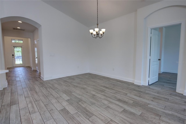 1727 Butterfly Way, Longwood, FL 32750 - spare room featuring arched walkways, light wood-style flooring, a chandelier, baseboards, and lofted ceiling