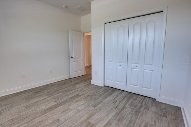 1727 Butterfly Way, Longwood, FL 32750 - unfurnished bedroom with light wood-type flooring, a closet, and baseboards