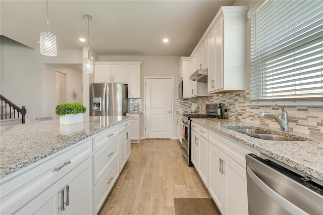 2793 Nature View Rd, Saint Cloud, FL 34771 - kitchen with appliances with stainless steel finishes, a sink, under cabinet range hood, decorative backsplash, and white cabinetry