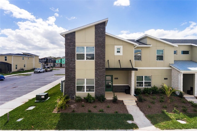 4184 Paragraph Dr, Kissimmee, FL 34746 - contemporary house with stucco siding, stone siding, a residential view, and a front lawn
