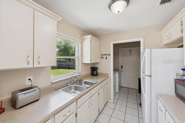 2822 Fulford St, Deltona, FL 32738 - kitchen with freestanding refrigerator, white cabinetry, light tile patterned flooring, and light countertops