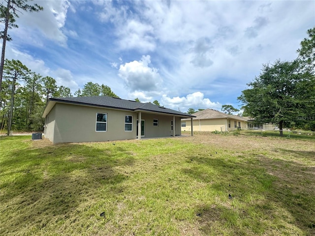 628 W Heronsbill Ln, Dunnellon, FL 34434 - back of house featuring stucco siding and a yard