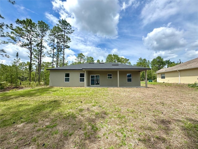 628 W Heronsbill Ln, Dunnellon, FL 34434 - back of house with stucco siding and a lawn