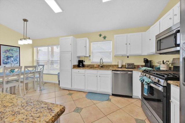 2627 Autumn Creek Cir, Kissimmee, FL 34747 - kitchen with appliances with stainless steel finishes, a sink, white cabinets, plenty of natural light, and lofted ceiling