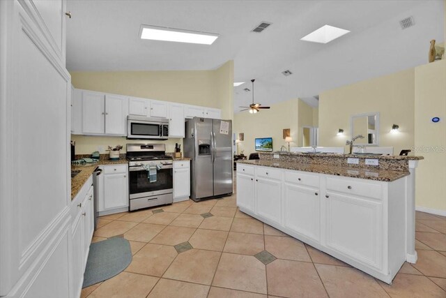 2627 Autumn Creek Cir, Kissimmee, FL 34747 - kitchen featuring stainless steel appliances, light tile patterned floors, white cabinetry, dark stone counters, and ceiling fan