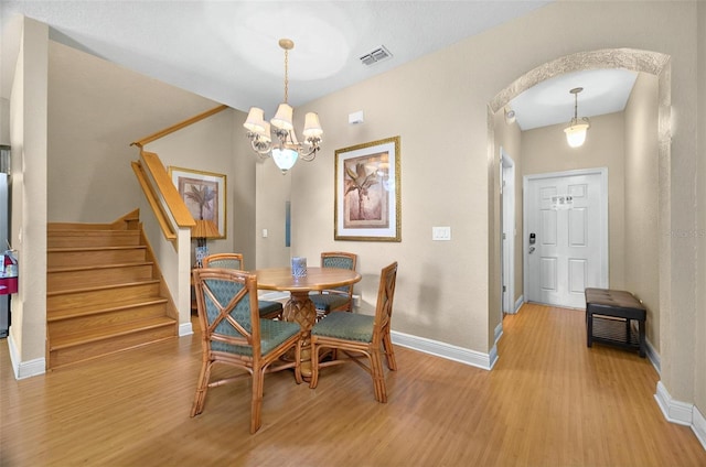 3725 Calabria Ave, Davenport, FL 33897 - dining space with wood finished floors, baseboards, a chandelier, and stairway