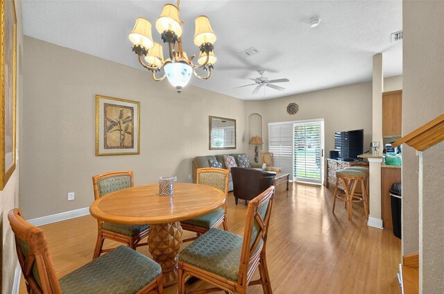 3725 Calabria Ave, Davenport, FL 33897 - dining space with light wood-style floors, a ceiling fan, a chandelier, and baseboards
