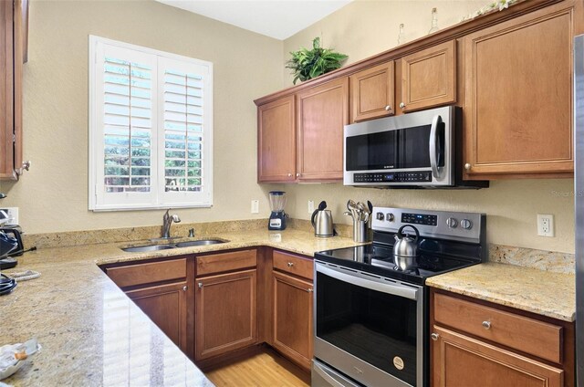 3725 Calabria Ave, Davenport, FL 33897 - kitchen featuring stainless steel appliances, a sink, and brown cabinets