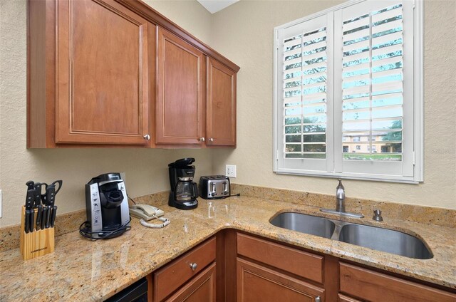 3725 Calabria Ave, Davenport, FL 33897 - kitchen featuring a sink, brown cabinetry, and light stone countertops
