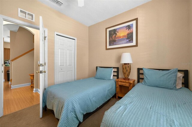 3725 Calabria Ave, Davenport, FL 33897 - carpeted bedroom with arched walkways, a closet, ceiling fan, wood finished floors, and baseboards