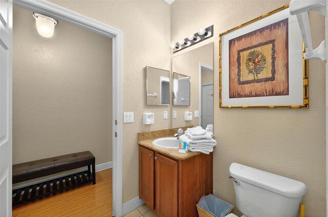 3725 Calabria Ave, Davenport, FL 33897 - bathroom with vanity, toilet, wood finished floors, and baseboards