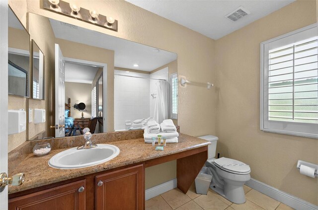 3725 Calabria Ave, Davenport, FL 33897 - full bath featuring toilet, curtained shower, tile patterned floors, vanity, and baseboards