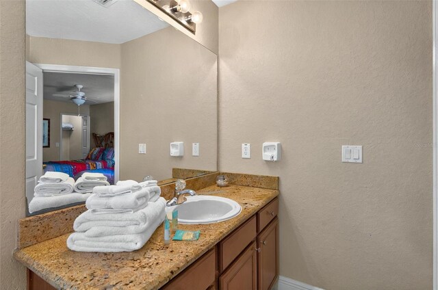 3725 Calabria Ave, Davenport, FL 33897 - bathroom with vanity, ensuite bathroom, a textured wall, and ceiling fan