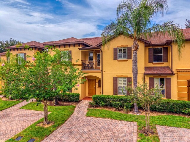 3725 Calabria Ave, Davenport, FL 33897 - view of front of house featuring a balcony and stucco siding