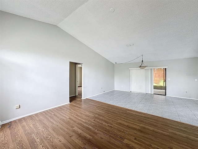 7337 Cone Shell Dr, Spring Hill, FL 34607 - spare room featuring wood finished floors, lofted ceiling, a textured ceiling, and baseboards
