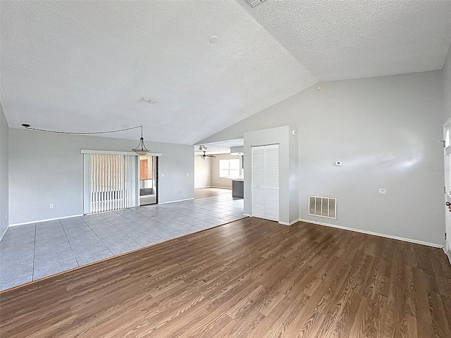 7337 Cone Shell Dr, Spring Hill, FL 34607 - unfurnished living room with wood finished floors, a ceiling fan, a textured ceiling, lofted ceiling, and baseboards
