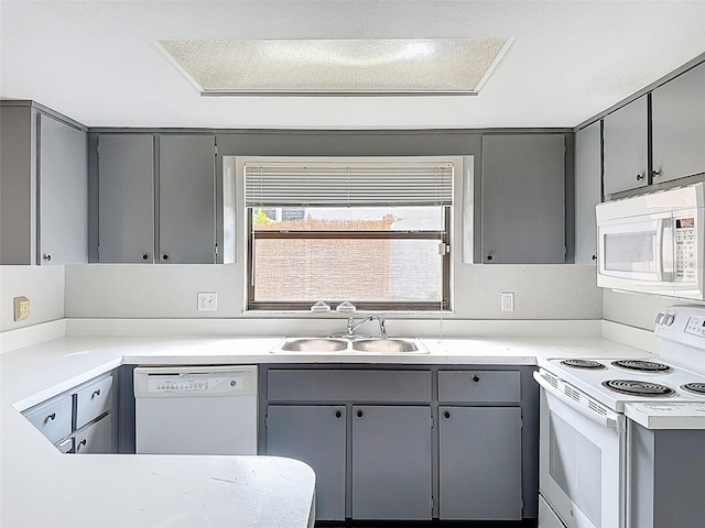 7337 Cone Shell Dr, Spring Hill, FL 34607 - kitchen featuring white appliances, gray cabinetry, a sink, and light countertops