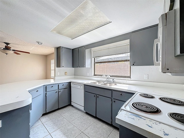 7337 Cone Shell Dr, Spring Hill, FL 34607 - kitchen featuring white appliances, a textured ceiling, a sink, light tile patterned flooring, and a peninsula