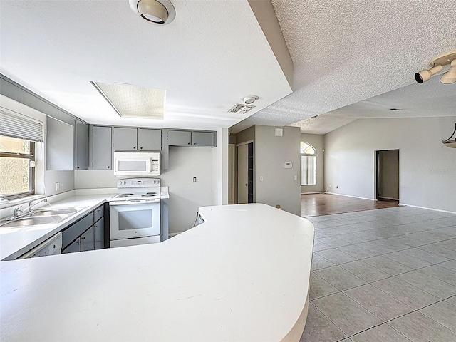 7337 Cone Shell Dr, Spring Hill, FL 34607 - kitchen with white appliances, gray cabinets, plenty of natural light, and a textured ceiling