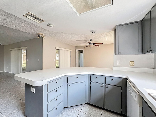 7337 Cone Shell Dr, Spring Hill, FL 34607 - kitchen with white dishwasher, a textured ceiling, light tile patterned floors, a peninsula, and light countertops