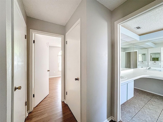 7337 Cone Shell Dr, Spring Hill, FL 34607 - hallway featuring a textured ceiling, baseboards, and wood finished floors