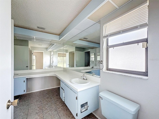 7337 Cone Shell Dr, Spring Hill, FL 34607 - bathroom with double vanity, toilet, tile patterned floors, and a textured ceiling