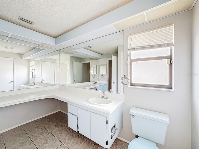 7337 Cone Shell Dr, Spring Hill, FL 34607 - bathroom with double vanity, tile patterned floors, toilet, a textured ceiling, and baseboards