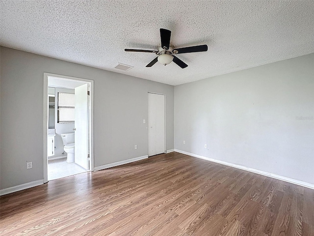 7337 Cone Shell Dr, Spring Hill, FL 34607 - unfurnished bedroom with wood finished floors, baseboards, a textured ceiling, and ceiling fan
