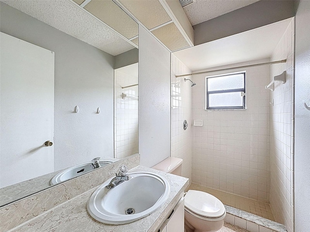 7337 Cone Shell Dr, Spring Hill, FL 34607 - full bathroom featuring vanity, toilet, a tile shower, and a textured ceiling