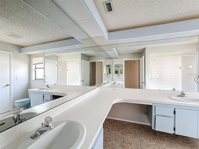 7337 Cone Shell Dr, Spring Hill, FL 34607 - bathroom featuring double vanity, toilet, tile patterned floors, and a textured ceiling