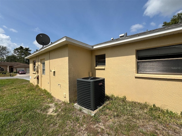 7337 Cone Shell Dr, Spring Hill, FL 34607 - view of side of property with central air condition unit, stucco siding, and a yard