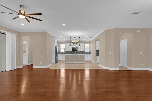 8348 Vivaro Isle Way, Windermere, FL 34786 - unfurnished living room with light wood-style flooring, crown molding, baseboards, a chandelier, and a ceiling fan