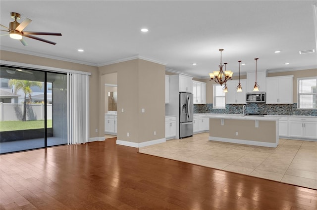 8348 Vivaro Isle Way, Windermere, FL 34786 - kitchen featuring stainless steel appliances, open floor plan, light countertops, decorative backsplash, and light wood-style floors