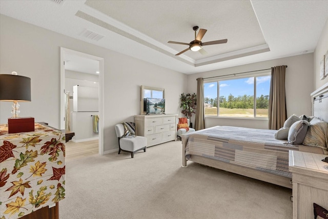 9846 SW 106th Ct, Ocala, F, Ocala, FL 34481 - bedroom featuring a tray ceiling, freestanding refrigerator, light colored carpet, ensuite bath, and ceiling fan