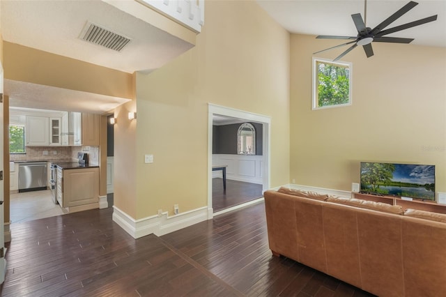 120 E Greentree Ln, Lake Mary, FL 32746 - unfurnished living room with a towering ceiling, a ceiling fan, wood finished floors, and baseboards