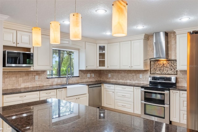 120 E Greentree Ln, Lake Mary, FL 32746 - kitchen with wall chimney range hood, appliances with stainless steel finishes, a sink, tasteful backsplash, and decorative light fixtures
