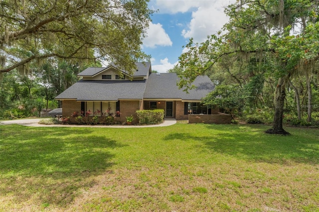 120 E Greentree Ln, Lake Mary, FL 32746 - view of front of property featuring a front lawn, a shingled roof, and brick siding