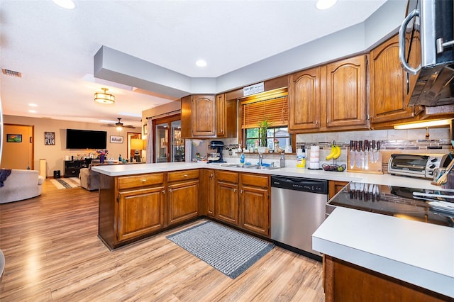 493 Princewood Dr, Deland, FL 32724 - kitchen featuring stainless steel appliances, a peninsula, brown cabinetry, light countertops, and recessed lighting