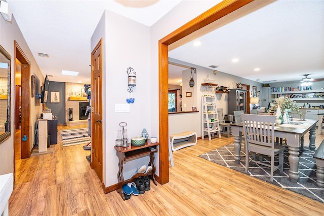 493 Princewood Dr, Deland, FL 32724 - dining space with light wood-style flooring, ceiling fan, baseboards, recessed lighting, and a brick fireplace