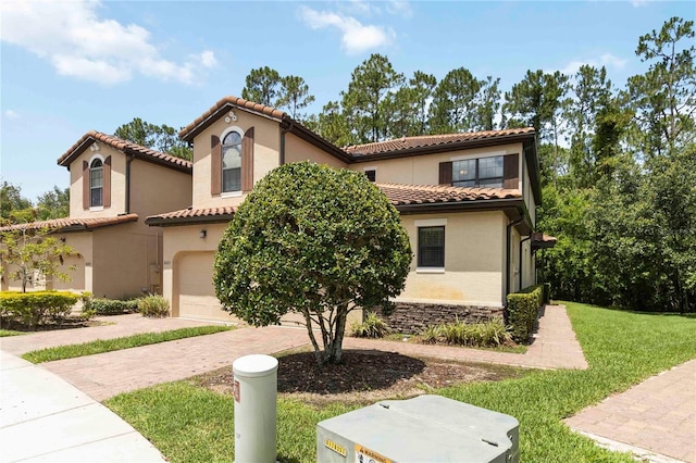 8219 Roseville Blvd, Davenport, FL 33896 - mediterranean / spanish home featuring a garage, decorative driveway, stucco siding, a tiled roof, and a front lawn