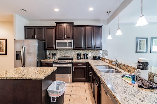 8219 Roseville Blvd, Davenport, FL 33896 - kitchen featuring appliances with stainless steel finishes, a sink, dark brown cabinetry, light stone counters, and backsplash