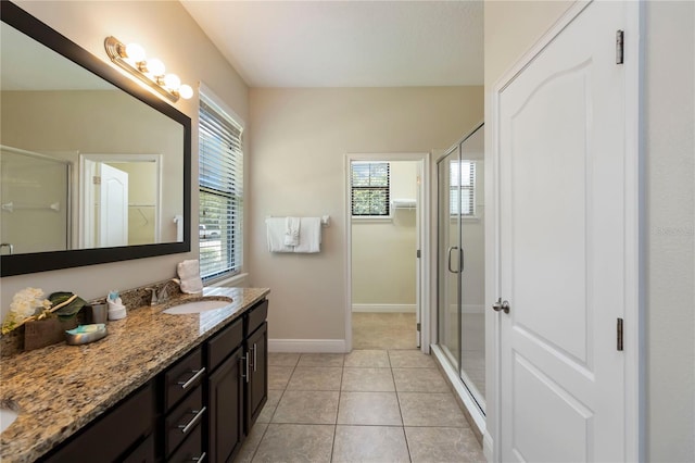 8219 Roseville Blvd, Davenport, FL 33896 - bathroom featuring vanity, a stall shower, baseboards, a walk in closet, and tile patterned floors