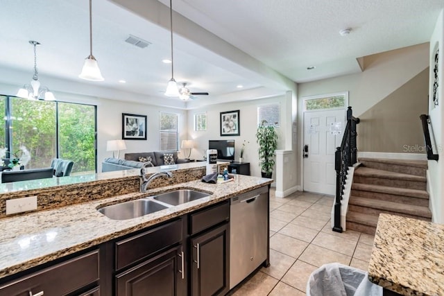 8219 Roseville Blvd, Davenport, FL 33896 - kitchen with a sink, stainless steel dishwasher, dark brown cabinetry, hanging light fixtures, and light tile patterned floors