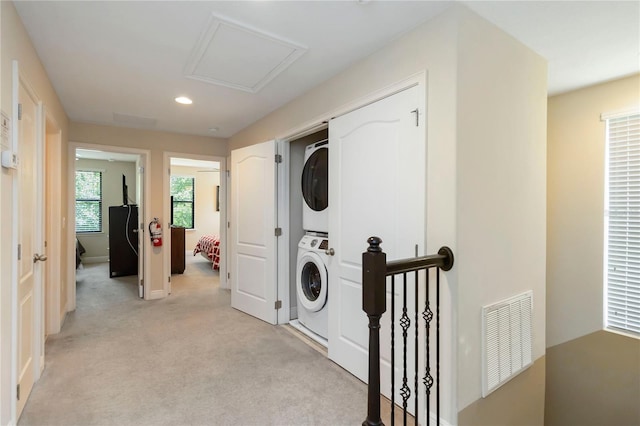 8219 Roseville Blvd, Davenport, FL 33896 - washroom featuring stacked washing machine and dryer, light colored carpet, recessed lighting, and baseboards