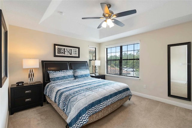 8219 Roseville Blvd, Davenport, FL 33896 - bedroom with light carpet, a tray ceiling, baseboards, and ceiling fan
