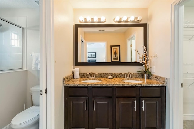8219 Roseville Blvd, Davenport, FL 33896 - bathroom with double vanity, a shower with shower door, toilet, and a spacious closet
