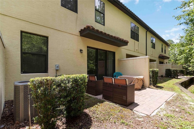 8219 Roseville Blvd, Davenport, FL 33896 - rear view of house featuring stucco siding, a patio, central air condition unit, and a tiled roof