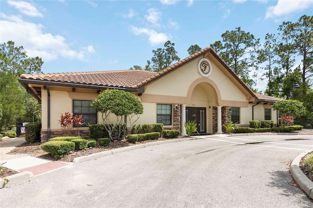 8219 Roseville Blvd, Davenport, FL 33896 - view of front of house featuring stone siding, uncovered parking, stucco siding, and a tiled roof