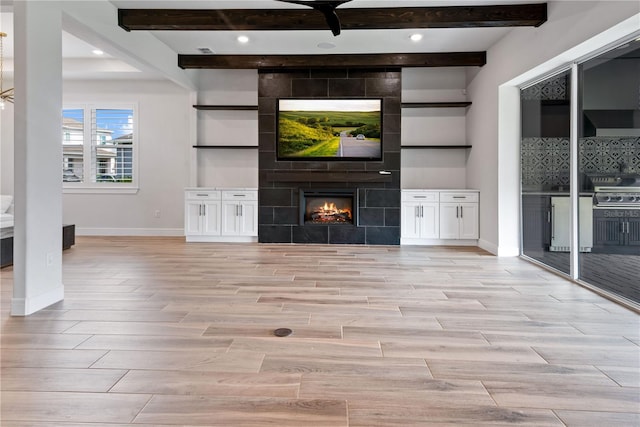 13323 Panama Beach Ct, Orlando, FL 32827 - unfurnished living room with light wood-type flooring, baseboards, beam ceiling, a tile fireplace, and recessed lighting